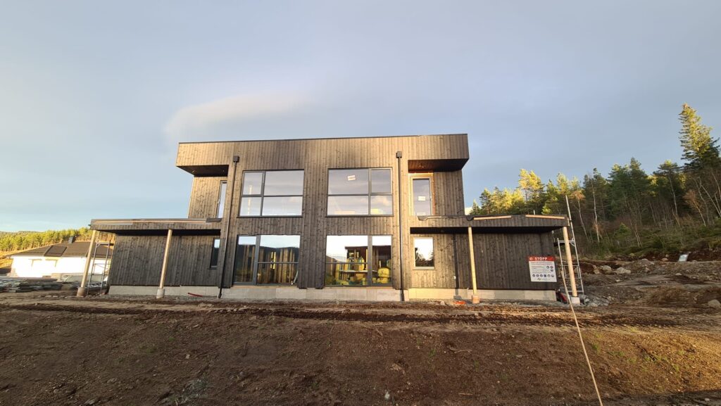 Modulpluss Sør - moderne arkitekturstil i svart tre, nybygg under bygging, fokus på bærekraftig boligbygging og skreddersydde løsninger for stø og område.